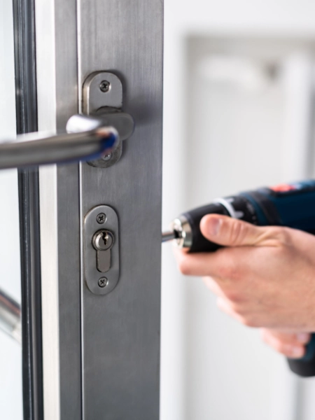 Hausmeister führt Wartungsarbeit an einer Tür aus – Objektbetreuung und technischer Service in Regensburg.